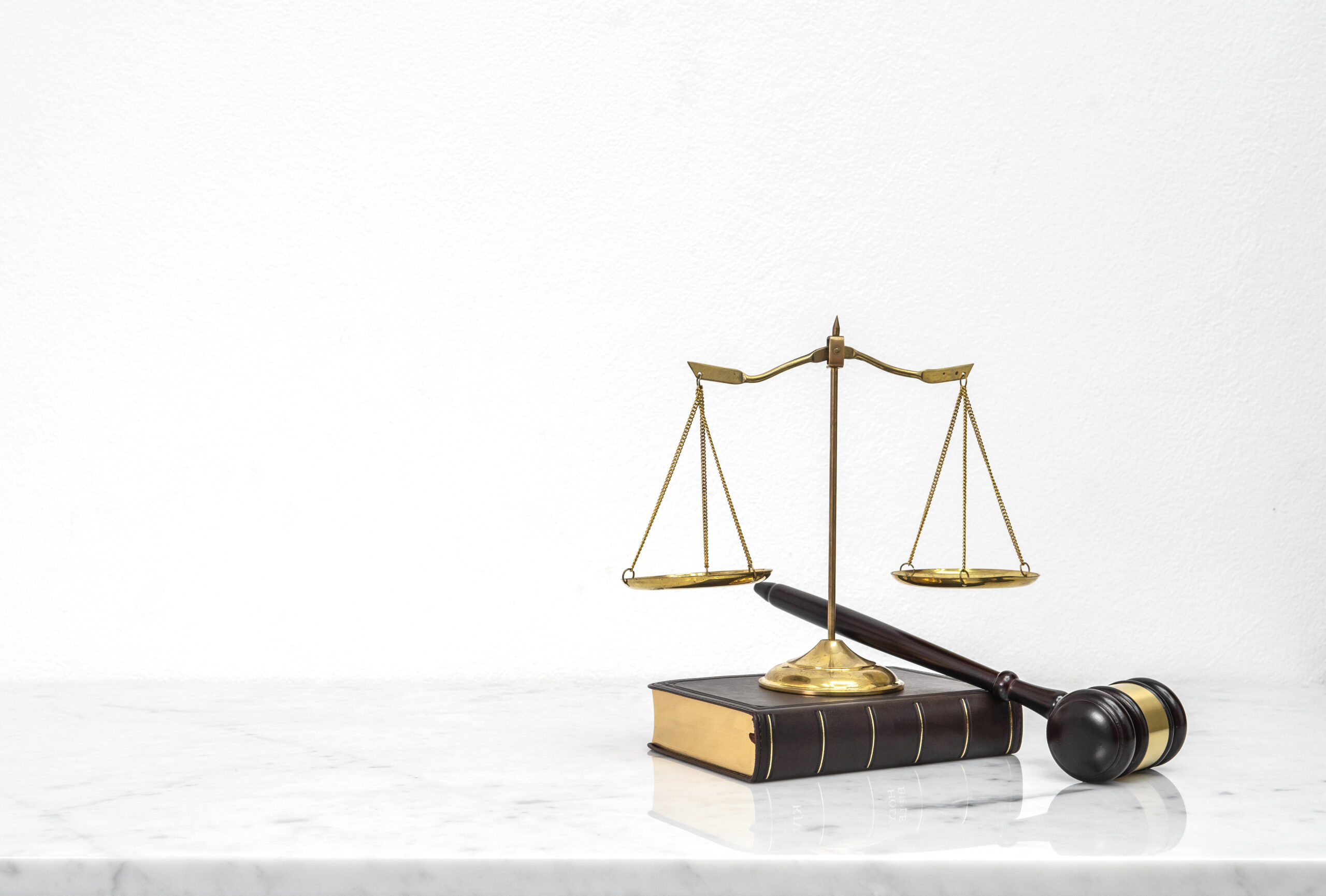 Wooden gavel and law book put on white marble table top counter